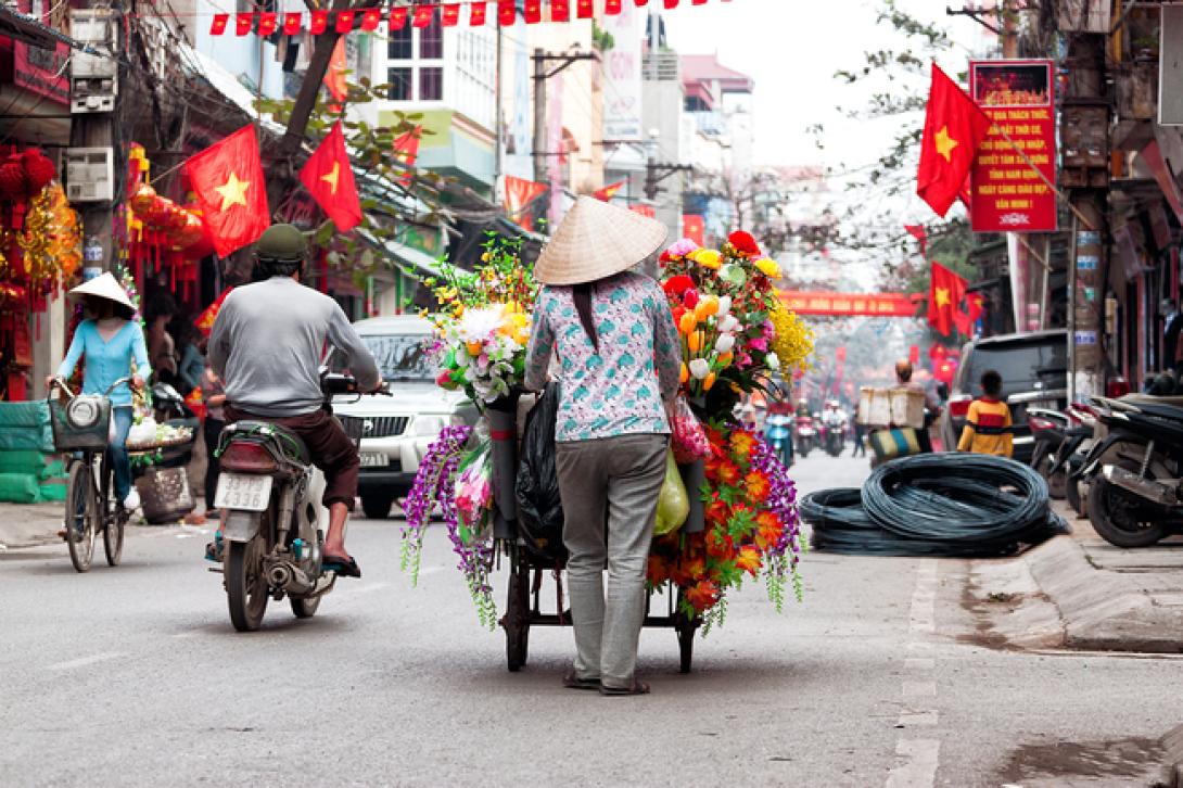 Merchants and commuters in Vietnam moving through the streets A busy street in Vietnam with merchants and commuters travelling up and down the road
